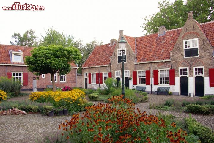 Immagine Un cortile fiorito a Naaldwijk, Olanda. Da notare anche gli infissi rossi in legno che impreziosiscono le facciate delle casette.