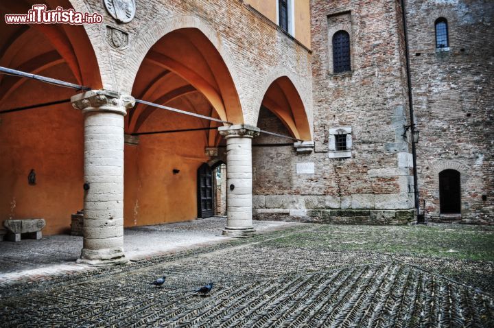 Immagine Un cortile rustico nel centro storico di Gradara, Italia. Porticato e decorazioni impreziosiscono questo bello spazio all'aperto all'interno di un edificio del borgo marchigiano