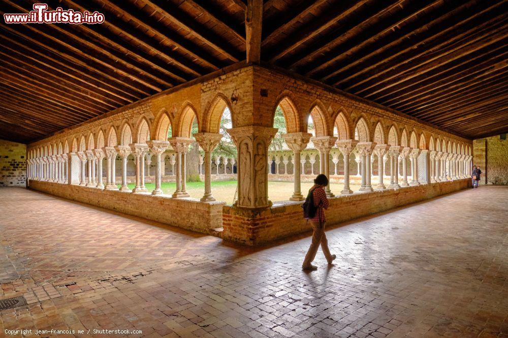 Immagine Un fedele nel chiostro dell'abbazia di Moissac (Francia) dedicata a San Pietro. Patrimonio dell'Umanità dell'Unesco, è un capolavoro dell'arte romanica - © jean-francois me / Shutterstock.com
