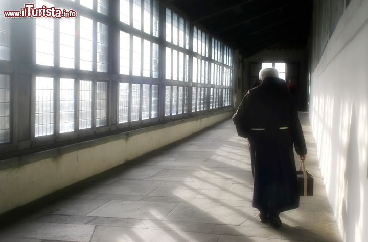 Immagine Un frate cammina in una galleria illuminata nel santuario della Verna, Toscana. Siamo a pochi chilometri da Chiusi della Verna, in provincia di Arezzo: questo santuario, destinazione per numerosi pellegrini, ospita cappelle e luoghi di preghiera e raccoglimento - © 168963716 / Shutterstock.com