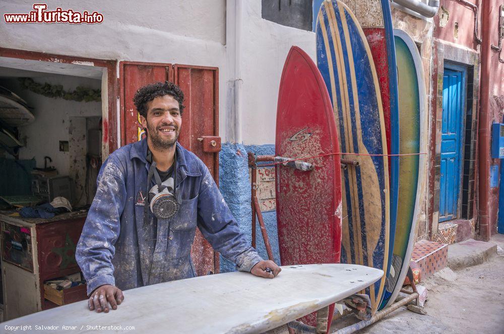 Immagine Un giovane artigiano costruisce tavole da surf in una bottega del villaggio di Taghazout, Marocco - © Salvador Aznar / Shutterstock.com
