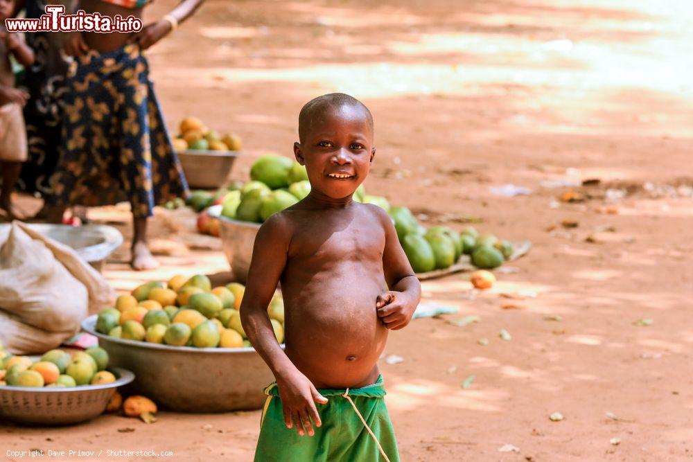 Immagine Un giovane ragazzino sorride in un mercato di frutta a Ouagadougou, Burkina Faso - © Dave Primov / Shutterstock.com