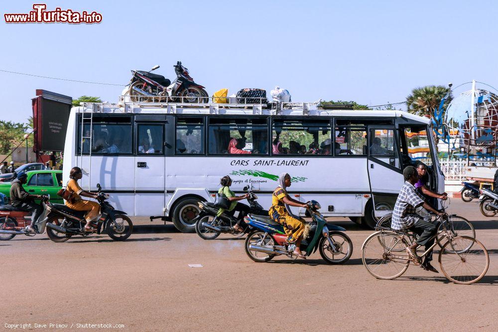 Immagine Un grande bus bianco affollato di passeggeri e merci in una strada di Ouagadougou, Burkina Faso (Africa) - © Dave Primov / Shutterstock.com