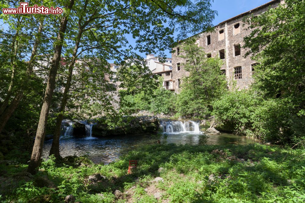 Immagine Un grazioso scorcio di Olot con vecchi edifici immersi nella vegetazione del lungofiume, Catalogna, Spagna.