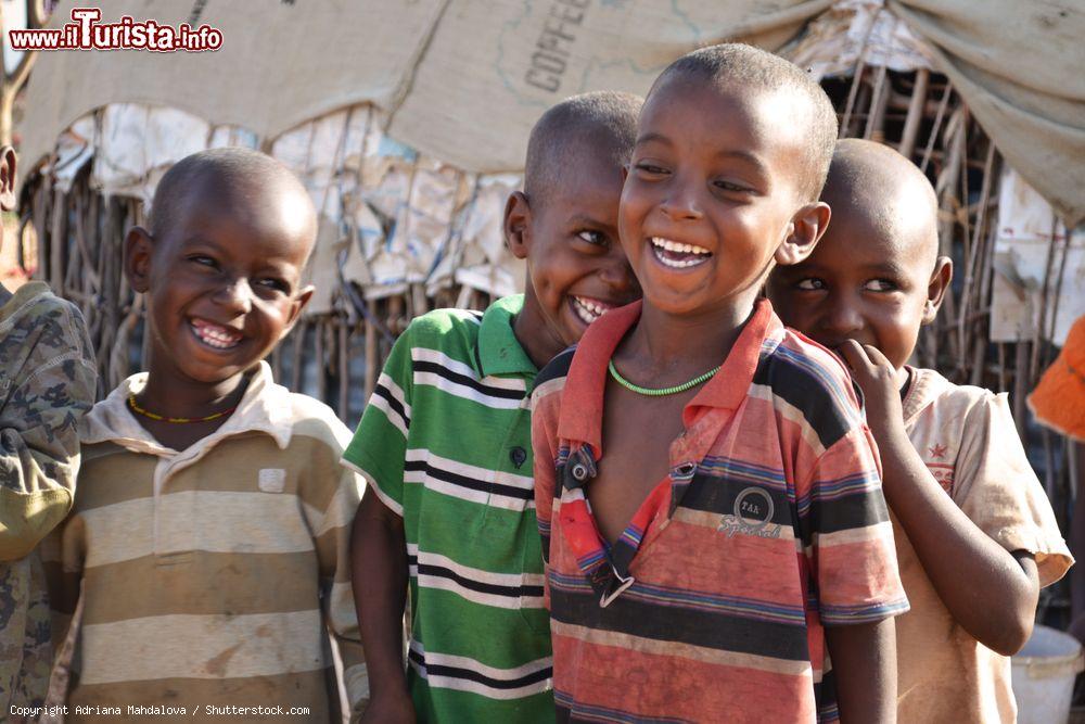Immagine Un gruppo di bambini ride divertito davanti alle case di Marsabit (Kenya) - © Adriana Mahdalova / Shutterstock.com