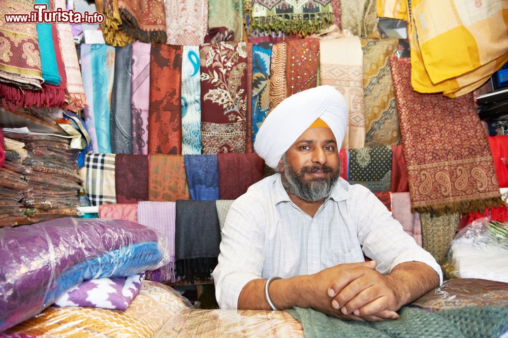 Immagine Un indiano sikh nel suo negozio di stoffe e scialli nella città di Amritsar, Punjab, India.