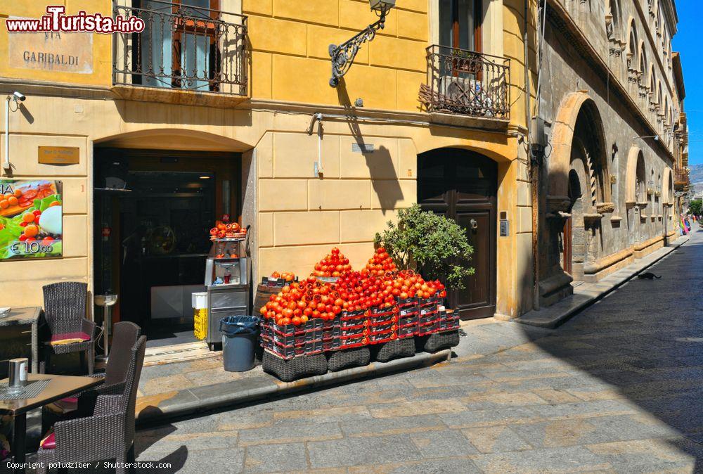 Immagine Un negozio in centro a Trapani con una bancarella di melograni - © poludziber / Shutterstock.com