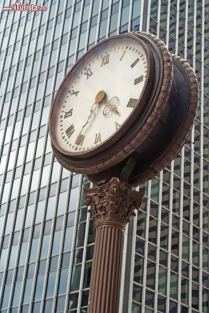 Immagine Un orologio su una strada del centro di Seattle, stato di Washington. Sullo sfondo, un grattacielo di vetro.