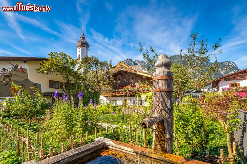 Immagine Un orto con legumi e fiori nel centro di Garmish-Partenkirchen, Germania. In primo piano, una fontana in legno.