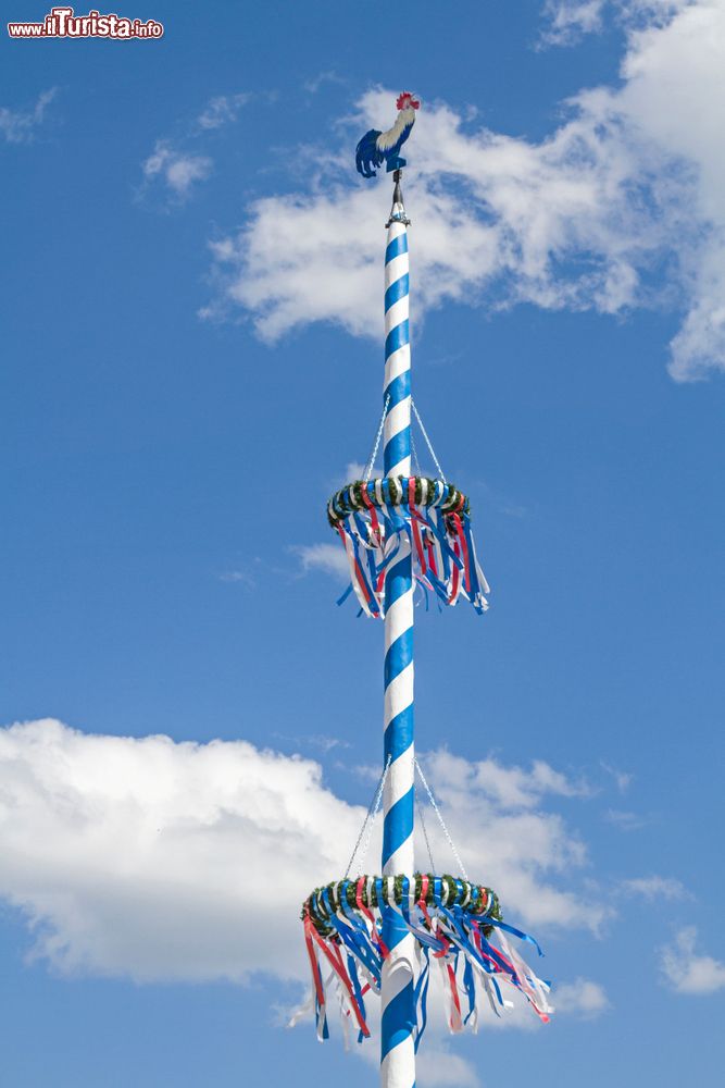 Immagine Un palo decorativo in una piazza del centro di Deggendorf, Germania. Sulla sommità, un simpatico galletto bianco, blu e rosso.