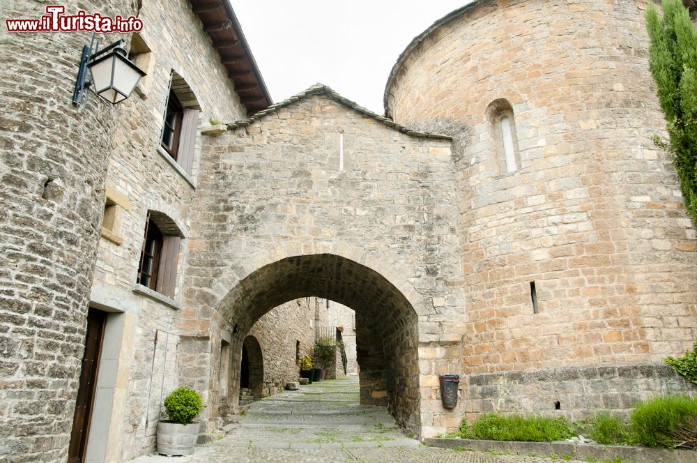 Immagine Un passaggio ad arco nel centro storico di Ainsa, Pirenei, Spagna. Le vecchie mura difensive abbracciano il cuore di questo villaggio in cui si possono ancora ammirare le tipiche case di un tempo sovrastate dalle chiese e dalle torri del castello.