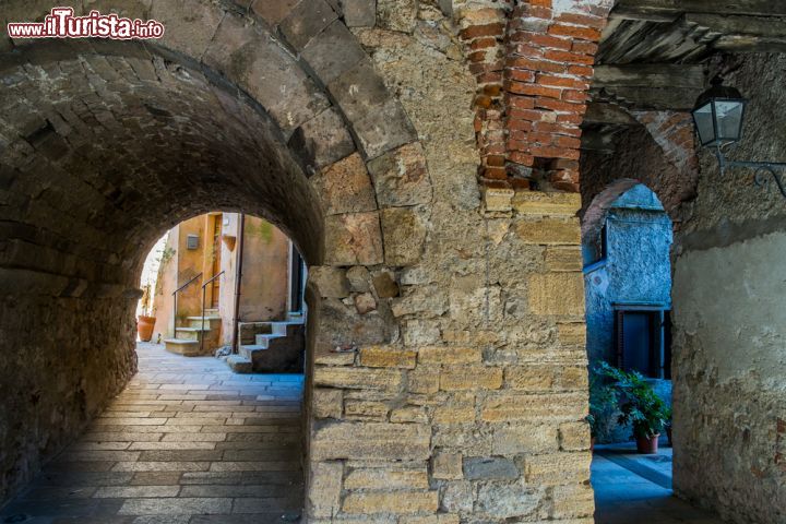 Immagine Un passaggio coperto nel centro storico di Capalbio, Toscana. Il borgo vecchio offre scorci fotografici di grande bellezza - © robertonencini / Shutterstock.com