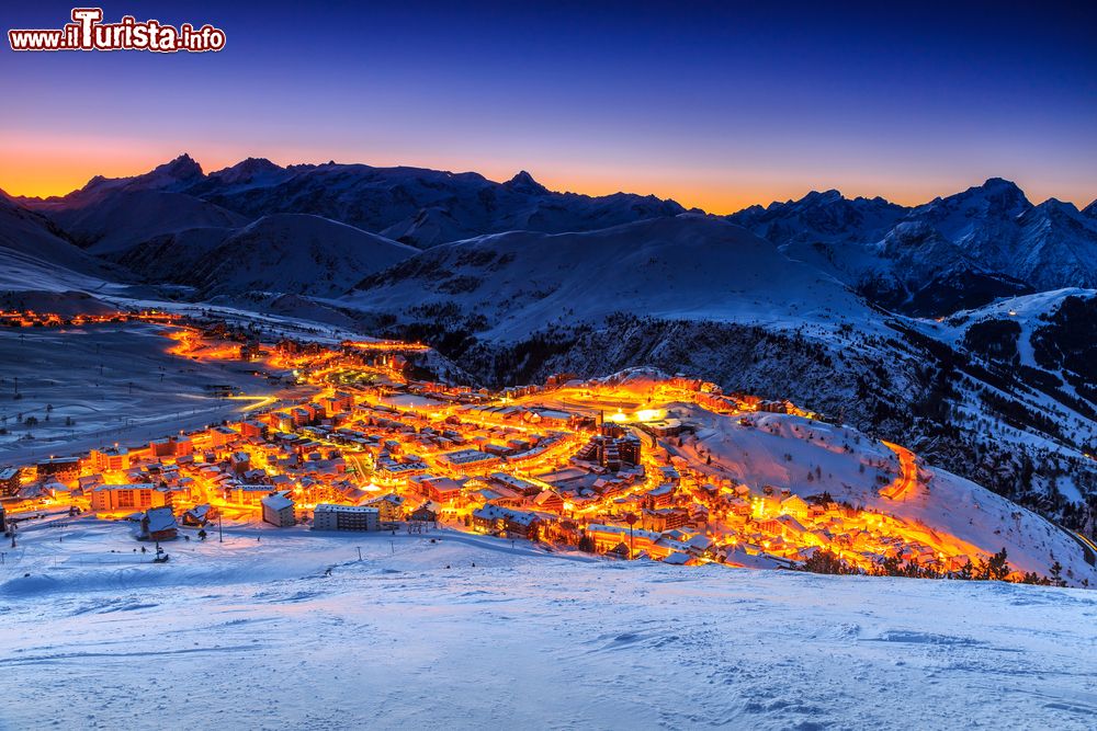 Immagine Un pittoresco panorama invernale by nigth dello ski resort dell'Alpe d'Huez, Francia. Questa stazione sciistica è nata nel 1936 ed è una delle più grandi di tutta la Francia con 249 chilometri di piste e un dislivello di 2230 metri.