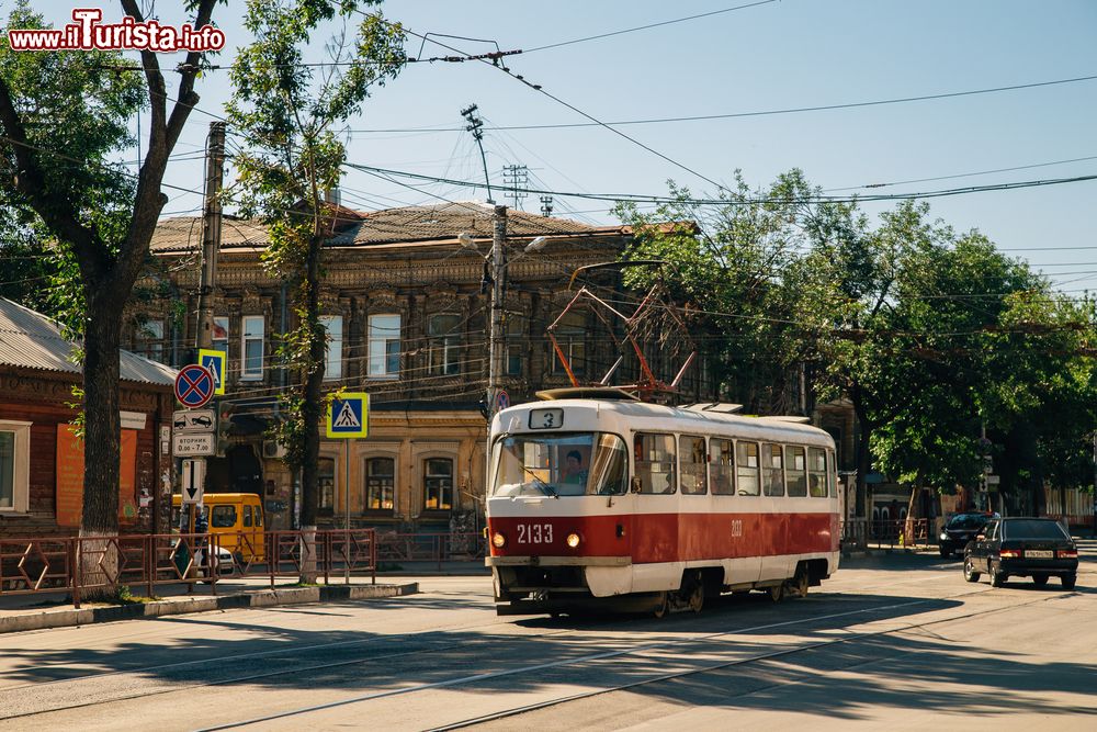 Immagine Un pittoresco scorcio di Samara, Russia, con vecchie case in legno e il tram numero 3 intento a transitare in una strada cittadina.