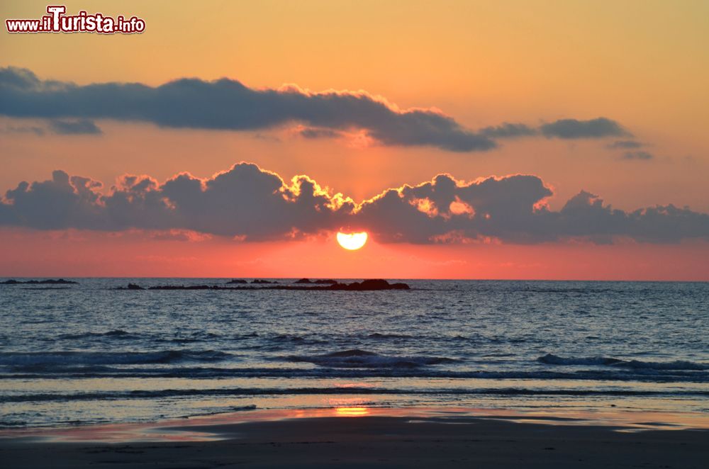 Immagine Un pittoresco tramonto su una spiaggia di Viana do Castelo, Portogallo. I colori del cielo si riflettono sull'acqua dell'oceano Atlantico.