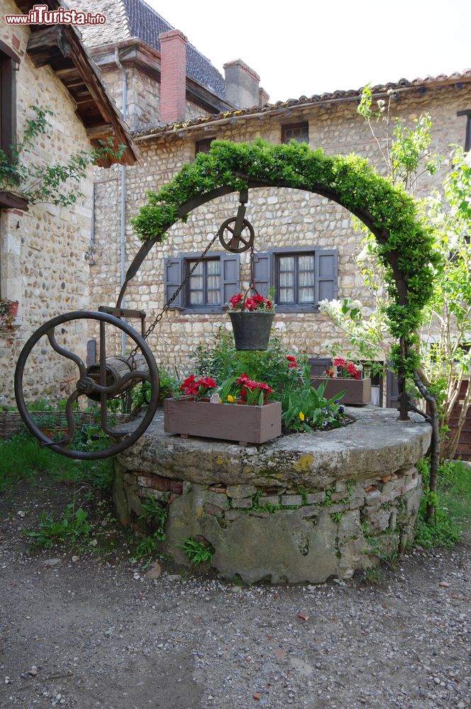 Immagine Un pozzo in pietra nel cortile di una casa nel borgo di Perouges, Francia.