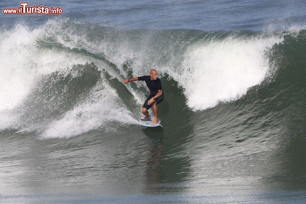 Immagine Un surfer cavalca un'onda al largo di Puerto Escondido, Messico. In alcuni tratti di spiaggia onde di 4-5 metri si abbattono sul bagnasciuga per la gioia degli appassionati di surf.