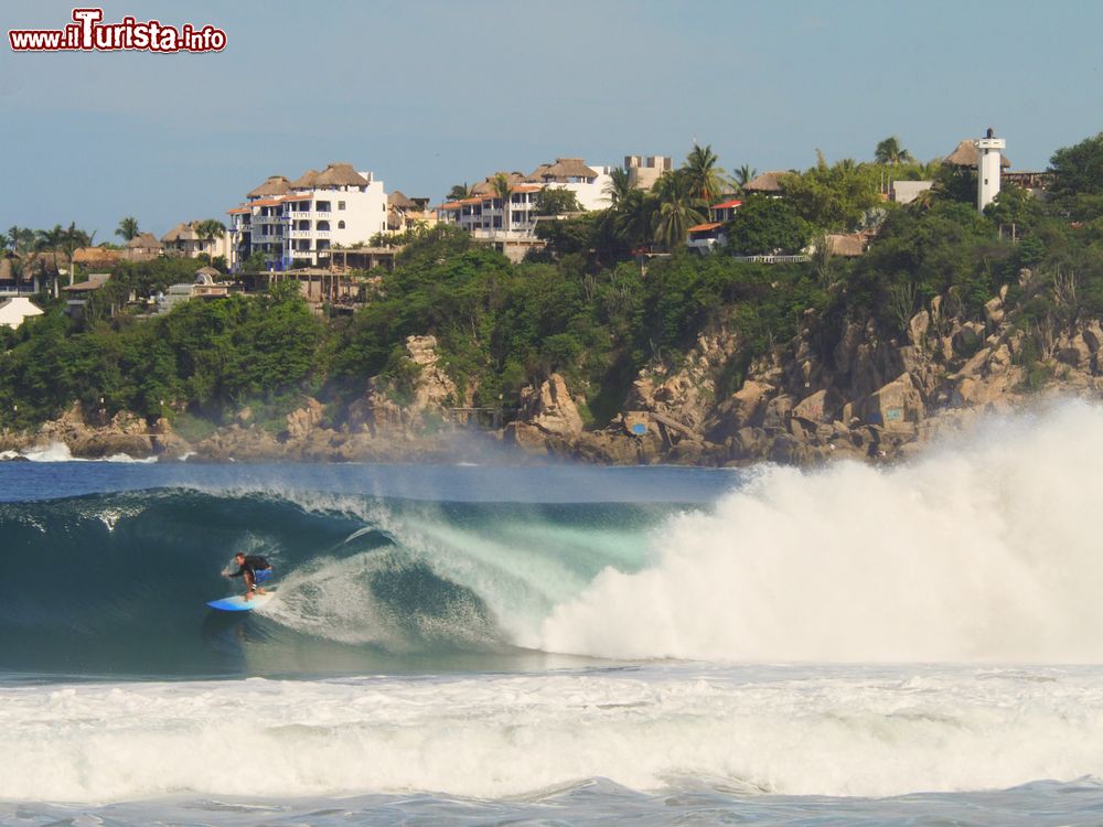 Immagine Un surfer fra le onde di Playa Zicatela a Puerto Escondido, Messico. Molto frastagliata e con piccole baie e insenature, la costa di Puerto Escondido è nota in tutto il mondo per gli annuali campionati di surf.