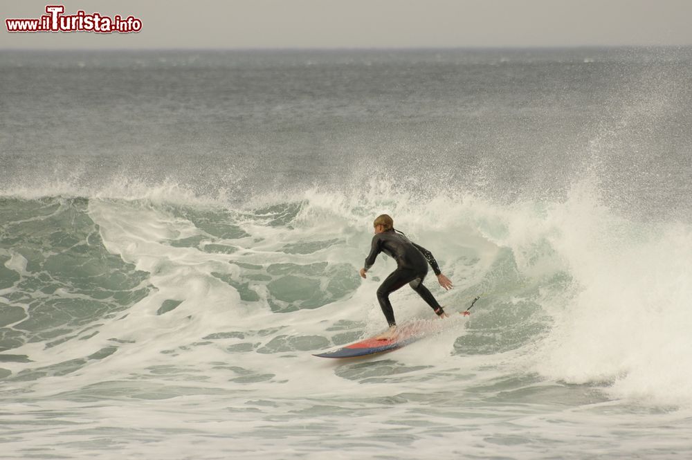 Immagine Un surfista cavalca le onde a Bells Beach, Torquay, Australia. Questa rinomata spiaggia da surf, situata a 100 km da Melbourne, nei pressi di Torquay, si trova sulla Great Ocean Road.