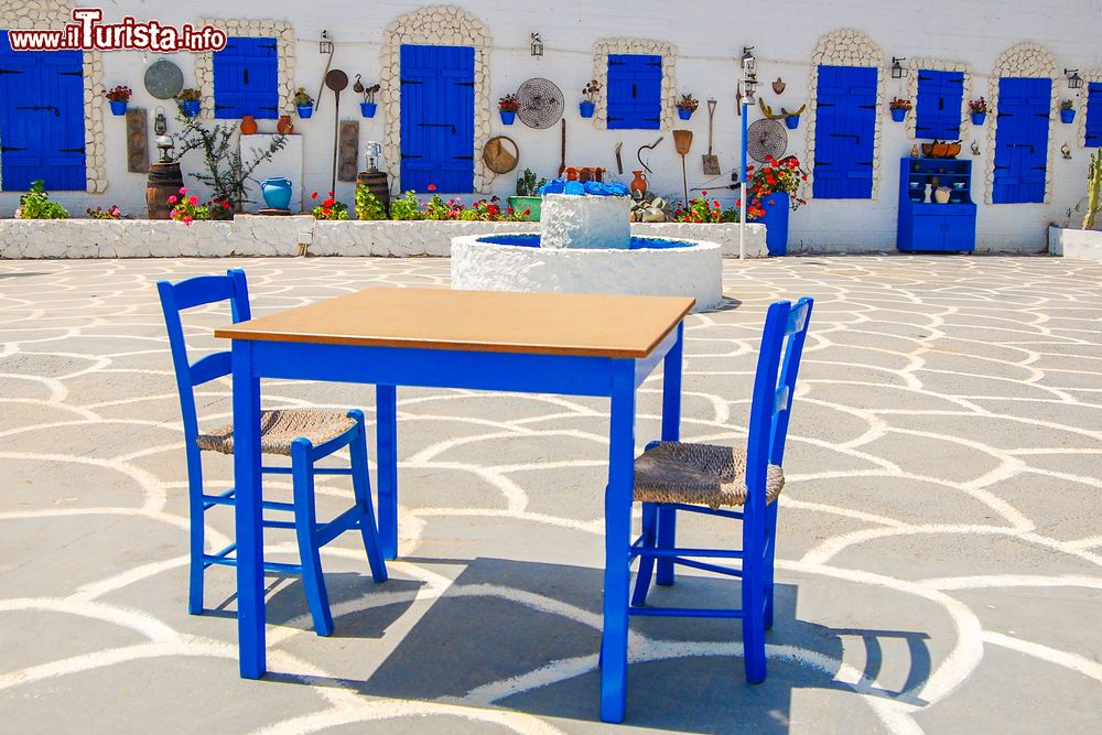 Immagine Un tavolo con sedie nella piazza del villaggio di Protaras, isola di Cipro. Questa località è caratterizzata dalla tradizionale architettura greca.