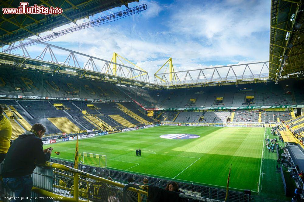 Immagine Un tifoso del Borussia Dortmund con il cellulare nello stadio cittadino, Germania. Inaugurato nell'aprile 1974 in vista dei mondiali tedeschi, il Signal Iduna Park ospita le partite casalinghe del Borussia Dortmund ed è il più grande impianto calcistico della Germania - © pkul / Shutterstock.com
