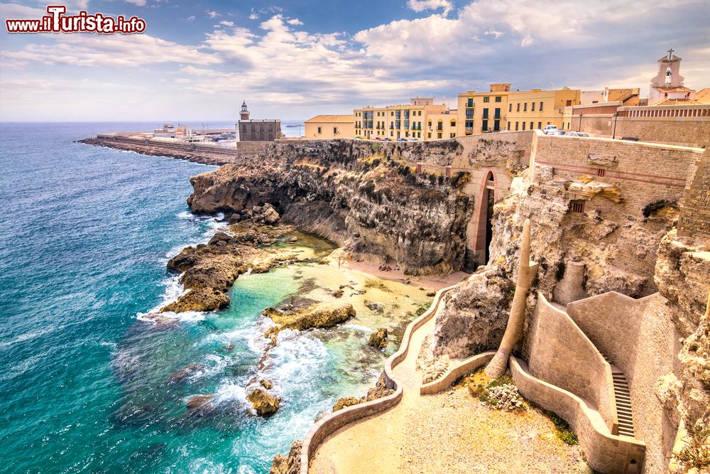 Immagine Un tratto delle mura fortificate di Melilla, Spagna: sullo sfondo della costa rocciosa, il faro e il porto cittadino di questa enclave in territorio marocchino.