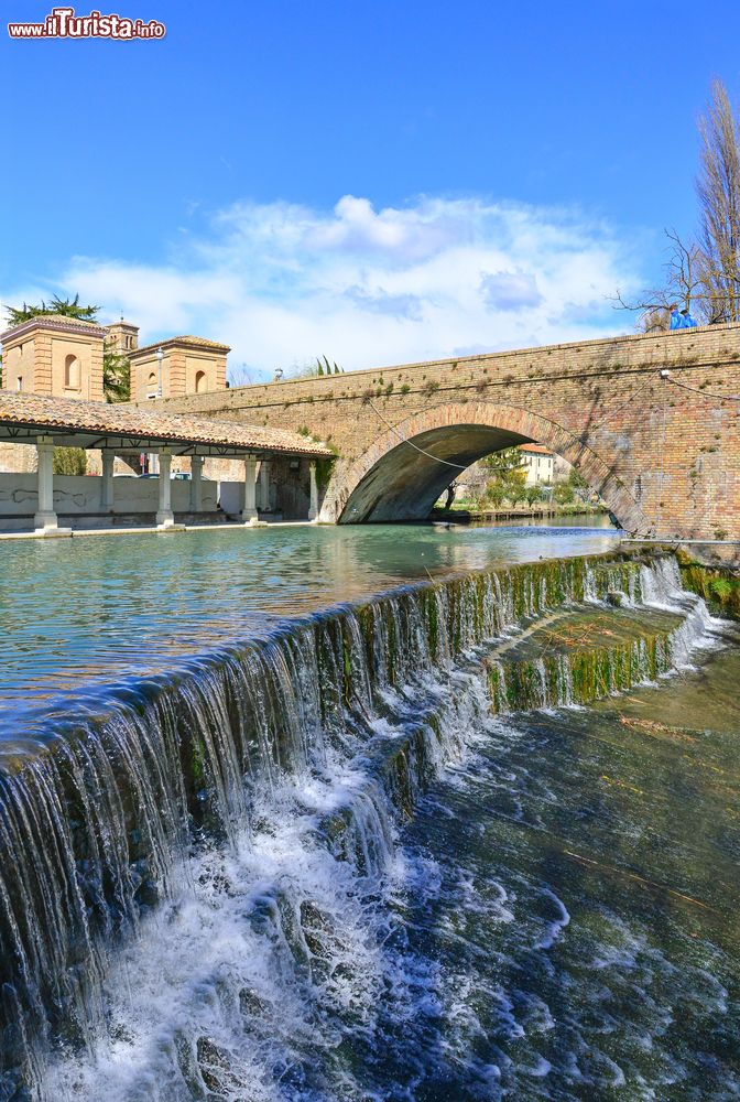 Immagine Un tratto di mura cittadine a Bevagna, Umbria, Italia. In primo piano un corso d'acqua che scorre limpido nel centro umbro.