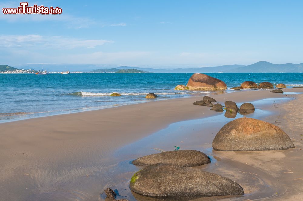 Immagine Un tratto di Ponta das Canas a Florianopolis, Brasile, con le suggestive formazioni rocciose che affiorano dall'acqua dell'oceano.