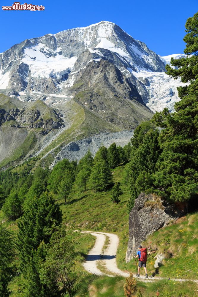 Immagine Un trekker su uno sterrato di montagna ad Arolla, Svizzera. Questi monti ospitano panorami mozzafiato per gli appassionati di trekking.