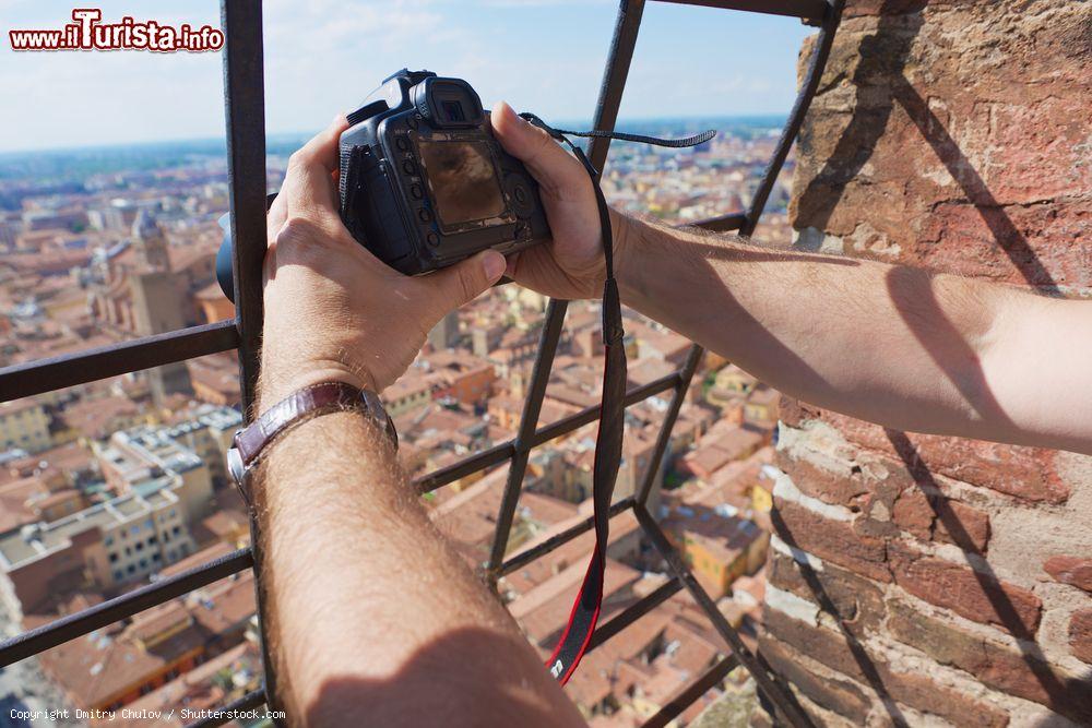 Immagine Un turista scatta una fotografia dalla cima della Torre degli Asinelli a Bologna, Emilia-Romagna - © Dmitry Chulov / Shutterstock.com