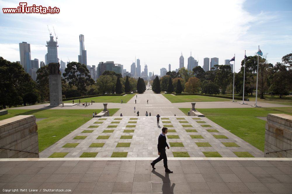 Immagine Un uomo cammina al Tempio della Rimembranza di Melbourne, Australia. Sullo sfondo, la skyline della città - © Matt Leane / Shutterstock.com