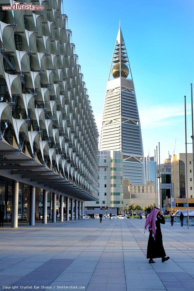 Immagine Un uomo cammina nei pressi del Saudi National Museum Park a Riyadh, Arabia Saudita. Sullo sfondo, Al Faisaliyah Center Tower lungo Olaya Street - © Crystal Eye Studio / Shutterstock.com