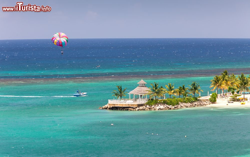 Immagine Un uomo con il paracadute si diverte sopra le splendide acque del mare dei Caraibi a Ocho Rios, Giamaica.