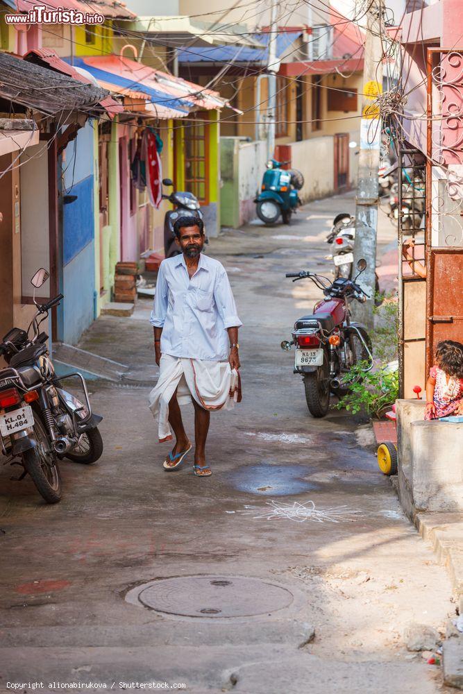 Immagine Un uomo con indosso un dhoti cammina lungo una strada di Trivandrum, India. Si tratta di un tradizionale indumento simile ad un pareo indossato dagli uomini in India - © alionabirukova / Shutterstock.com