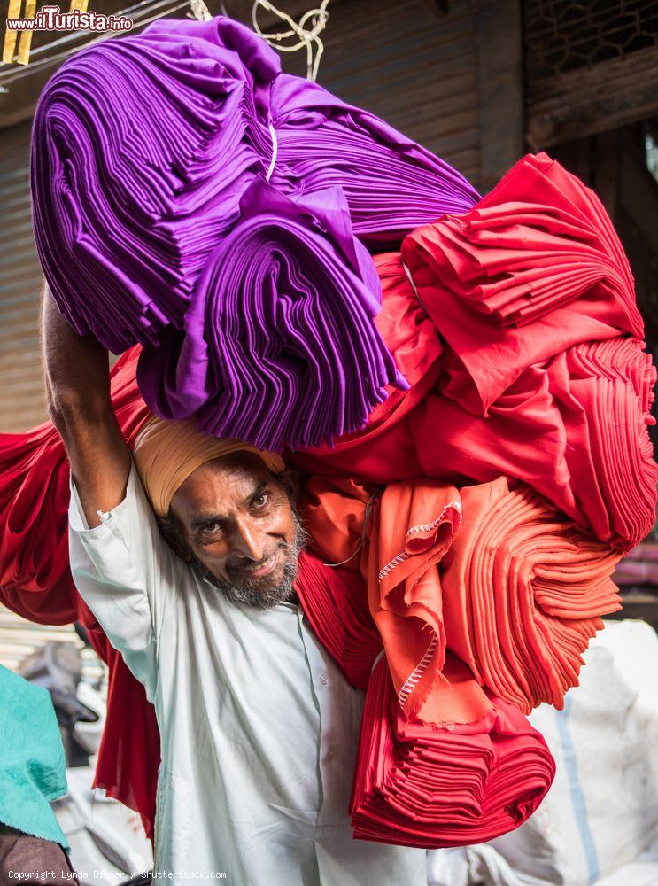 Immagine Un uomo con stoffe colorate nel vecchio mercato della città di Amritsar, Punjab, India. Il nome di questa località, considerata la "porta d'ingresso" dell'India per chi desidera entrare nel paese attraversando Turchia, Iran e Pakistan, significa "lago d'Ambrosia" - © Lynda Disher / Shutterstock.com