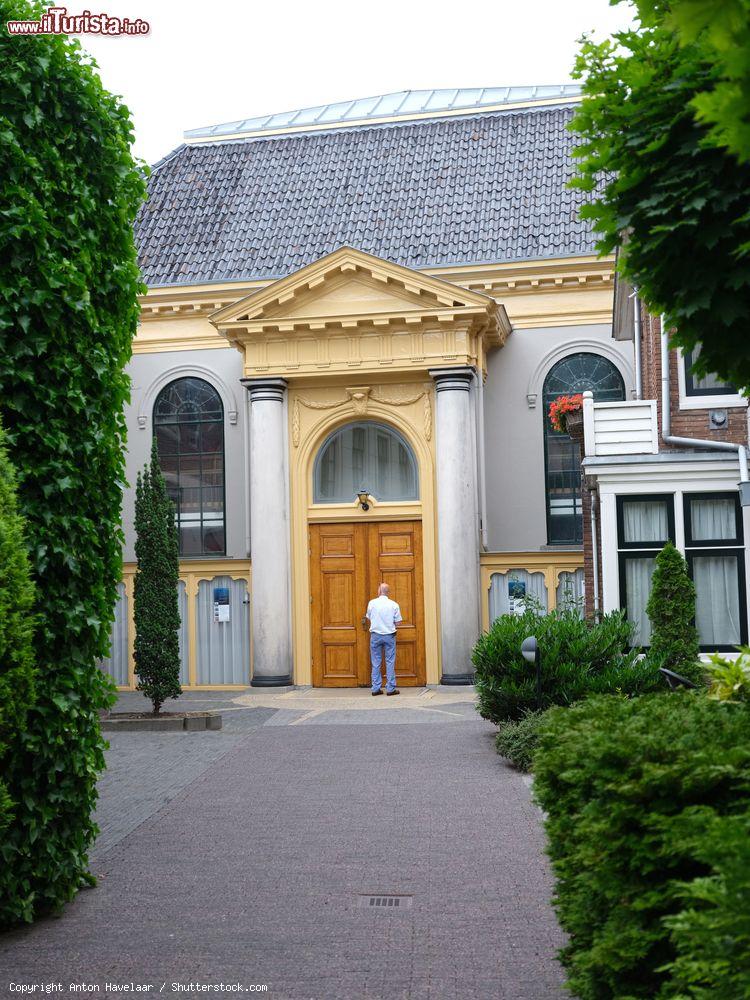 Immagine Un uomo di fronte a una vecchia chiesa nel centro di Leeuwarde, Paesi Bassi - © Anton Havelaar / Shutterstock.com