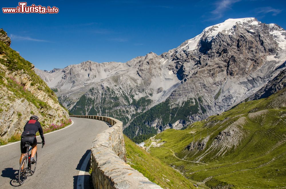 Immagine Un uomo in bicicletta sul Passo dello Stelvio, Lombardia/Trentino Alto Adige. Importante collegamento estivo per la sua grande vocazione turistica, il Passo dello Stelvio è anche meta ambita di ciclisti e motociclisti.