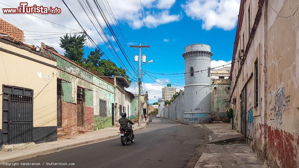 Immagine Un uomo in motorino lungo una via della città di Tegucigalpa, Honduras. Gli anni della colonizzazione spagnola sono tutt'ora visibili negli edifici - © Kanokratnok / Shutterstock.com