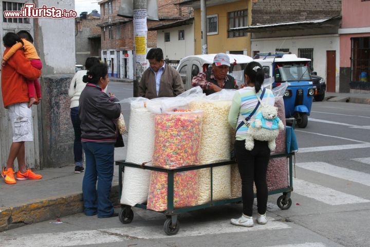 Immagine Un uomo intento a vendere cereali lungo una strada di Cajamarca, Perù. Passeggiando per il centro della città si incontrano spesso venditori ambulanti di riso soffiato e caramelle che si spostano con il loro carretto carico di sacchi - © Janmarie37 / Shutterstock.com