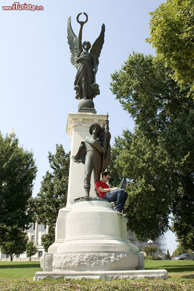 Immagine Un uomo lavora al computer seduto sul monumento ai Soldati Confederati dell'Arkansas, Little Rock.