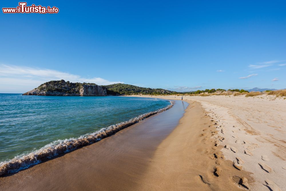 Immagine Un uomo passeggia sulla spiaggia della baia Luna a Gialova, Peloponneso, Grecia. La splendida laguna di Gialova si apre tra la costa Navarino e il porto di Pylos.