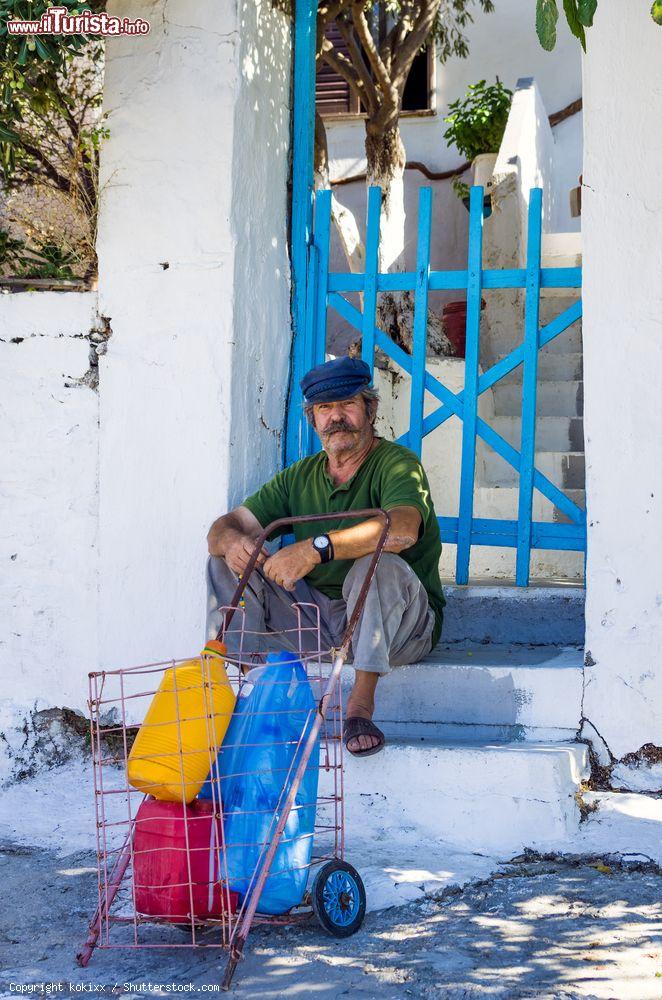 Immagine Un uomo seduto sui gradini di una casa a Inousses in Grecia - © kokixx / Shutterstock.com