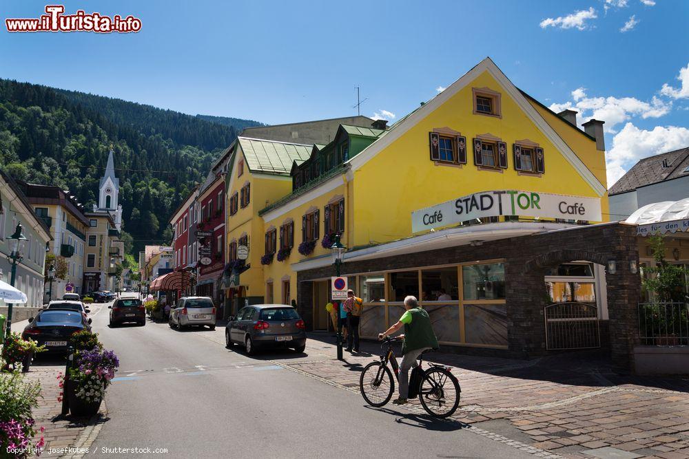 Immagine Un uomo su una bici elettrica di fronte ad un caffé nel centro di Schladming, Austria - © josefkubes / Shutterstock.com