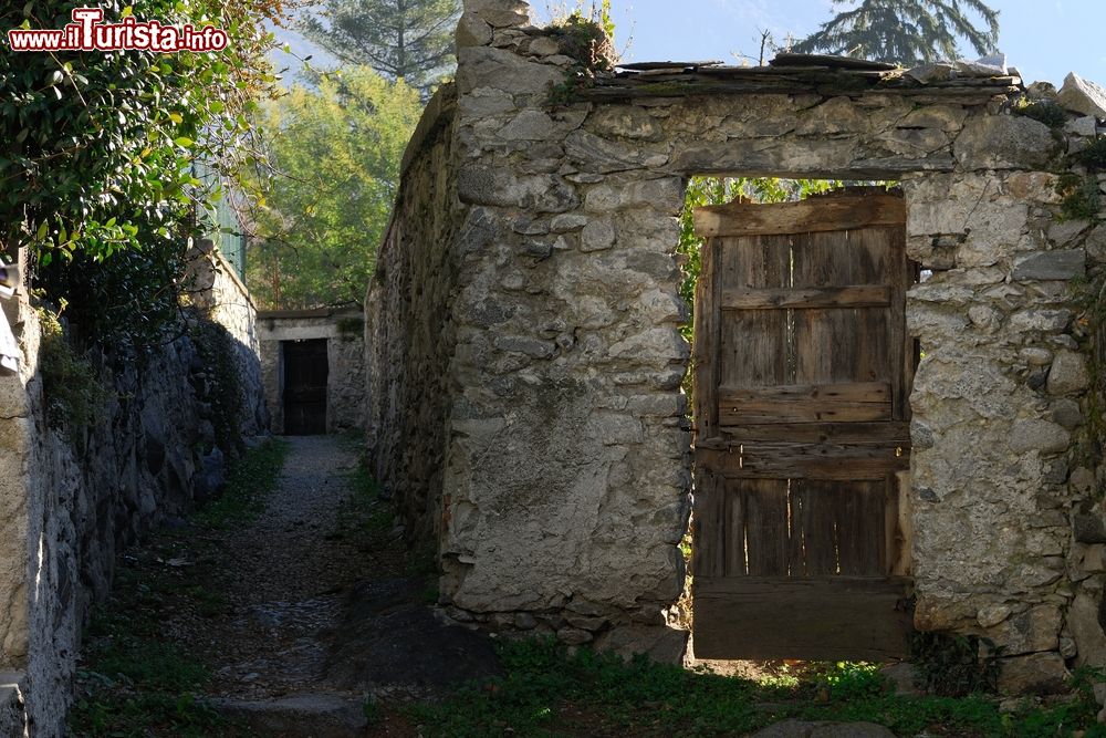 Immagine Un vecchio mura in pietra con porta in legno nella cittadina di Novate Mezzola, Lombardia.