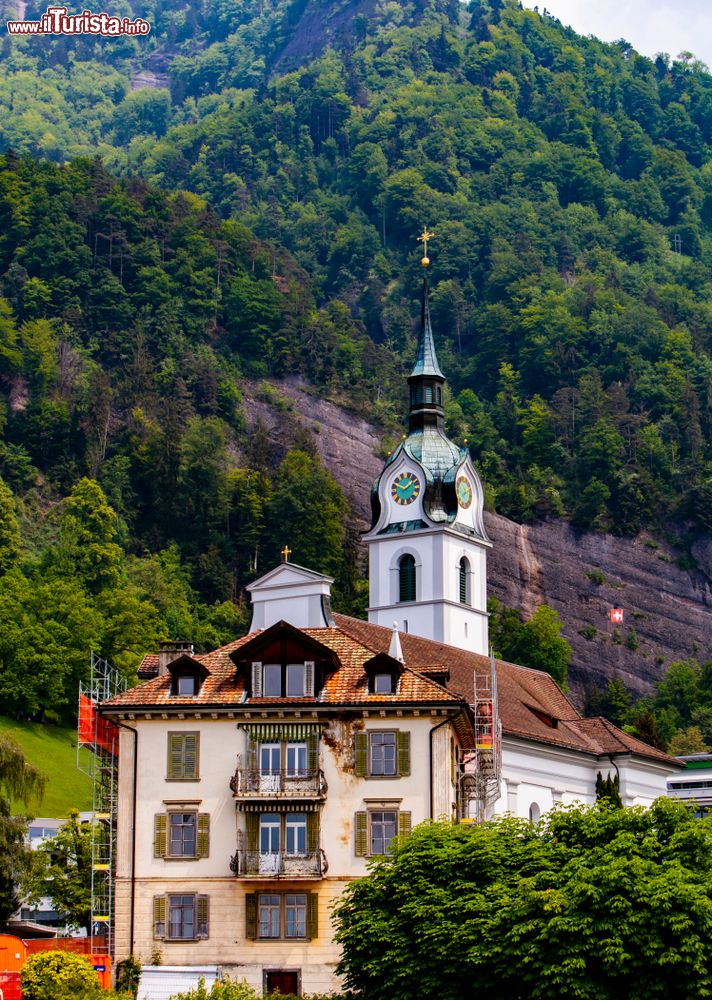 Immagine Un vecchio palazzo di Vitznau con dietro chiesa e campanile, Svizzera.