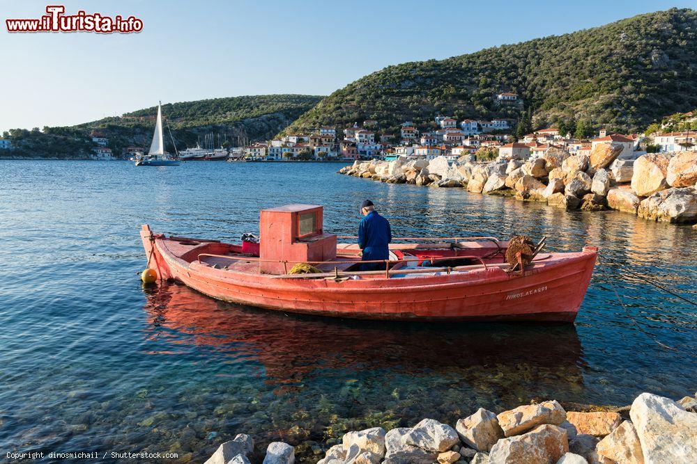 Immagine Un vecchio pescatore sulla sua barca in legno a Trikeri, Grecia. La pesca con le tradizionali imbarcazioni rimane un'attività importante per l'economia locale - © dinosmichail / Shutterstock.com