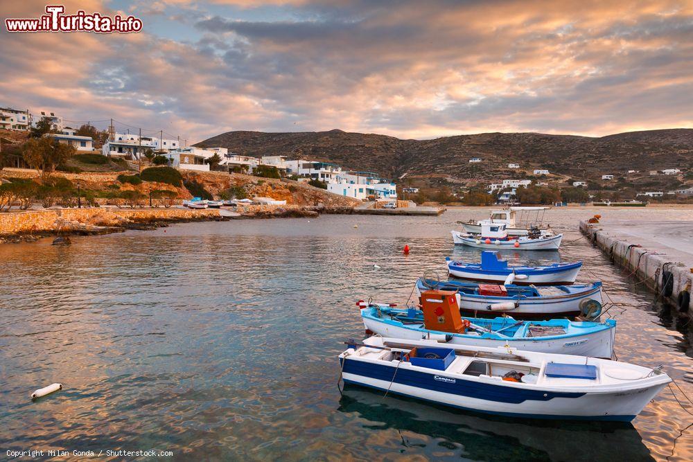 Immagine Un villaggio sull'isola di Donoussa fotografato al calar del sole, Grecia. In primo piano, le barche in legno ormeggiate al porto - © Milan Gonda / Shutterstock.com