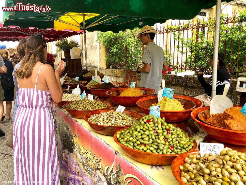 Immagine Una bancarella di olive e altri prodotti tipici al mercato di Monpazier, Francia - © Cmspic / Shutterstock.com