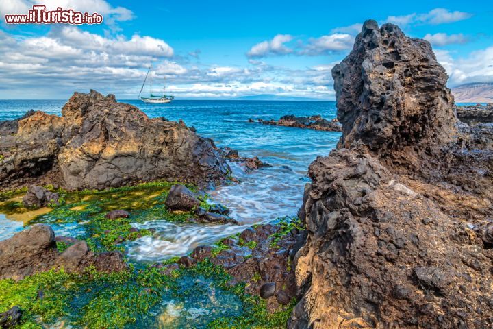 Immagine Una barca a vela ormeggiata al largo della costa di Kamaole Beach a Kihei, Hawaii.