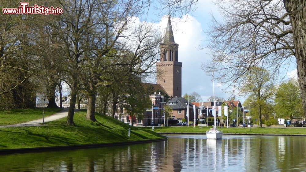 Immagine Una barca attraversa un canale di Leeuwarden con il campanile della chiesa, Paesi Bassi.